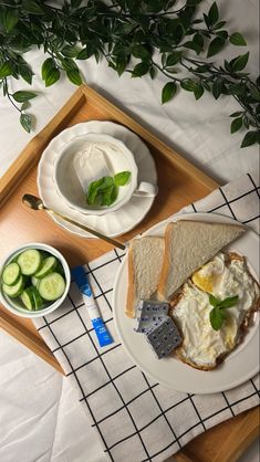 there is a tray with some food on it and two bowls of cucumbers