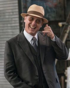 a man in a suit and hat pointing at something