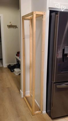 a refrigerator and freezer in a room with hard wood flooring on the ground