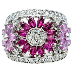 Ring Size: 6.75 Elevate your style with the enchanting allure of this Effy 14 karat white gold band ring. Crafted to captivate, its bold design features a stunning centerpiece: a radiant ruby flower with a dazzling diamond center. Surrounding it, two delicate blooms crafted from vibrant pink sapphires add a touch of elegance and sophistication. The band itself is adorned with a scattering of brilliant diamonds, both lining its edges and delicately interspersed within the center, enhancing its op Effy Ring, Effy Rings, Ruby Flower, Blink Blink, Wide Band Ring, Sapphire Color, Red Diamond, Flower Motif, Gold Band Ring