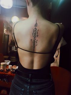 the back of a woman's neck with writing on it