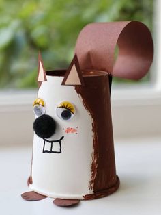 a toilet paper roll holder with a dog face painted on it and a brown nose