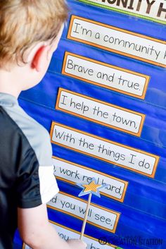 a young boy standing in front of a bulletin board