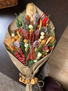 a bouquet of meats and vegetables wrapped in brown paper