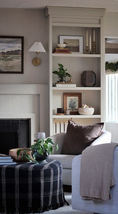 a living room filled with furniture and a fire place in front of a book shelf