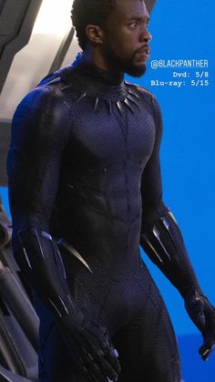 the black panther is standing in front of a blue screen with his hands on his hips