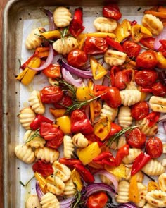 a pan filled with pasta and vegetables on top of a wooden table