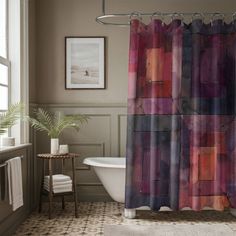 a bathroom with a bathtub, shower curtain and rugs in different colors on the floor