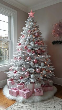 a white christmas tree with pink and silver ornaments