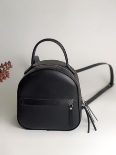 Small black backpack women made of genuine high-quality leather will not only dilute your style, but also free your hands from things. Green convertible backpack easily turns into a shoulder bag. Please note that due to the fact that each mini backpack is handcrafted from calfskin, sometimes they may have slight differences in color or tiny marks. This is completely natural. Product information: The convertible backpacks for women has adjustable shoulder straps and a convenient carry handle, straps have carbine, which allows you to detach one of the straps and carry the backpack over your shoulder. It has a main compartment, an inner pocket on the back of the bag, an outer zip pocket in the front. Material: Italy Vegetable tanned leather Skin color: outer color green, inside the backpack i Black Leather Softback Backpack With Adjustable Strap, Leather Backpack Perfect For Gift, Leather Backpack Bag For Gift, Gift Backpack With Zipper Closure, Leather Backpack Suitable As A Gift, School Bags With Leather Lining, Black Leather Backpack For School, Black Leather Softback Backpack For Everyday, Black Softback Leather Backpack For Everyday