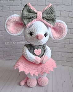 a crocheted mouse in a pink dress with a bow on it's head