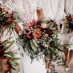 the bridesmaids are holding their bouquets with red and green flowers in them