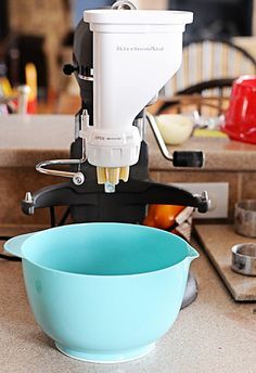 a blue bowl sitting on top of a counter next to a blender