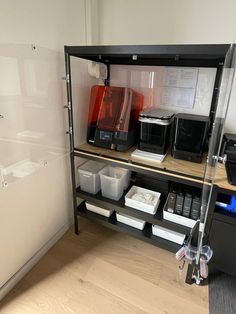 there is a shelf with many items on it in the room that includes coffee machines