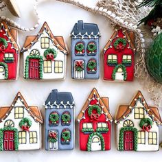 decorated gingerbread houses with holly wreaths and bells on them next to a christmas ornament