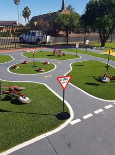 an artificial playground area with various play equipment on the ground and grass in the middle