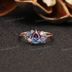 an image of a ring with three stones in it on a table next to flowers