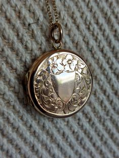 Lovely mid-century locket with a rose gold hue and fine engravings on both sides. A plain cartouche at the front could be engraved with initials or stay as is. It is surrounded by buttercup flowers and foliage. Details: The locket dates from the 1950s and if from the UK. It is stamped at the back "9ct back and front". Condition: The locket is in excellent antique condition, with only gentle surface wear and patina. The two original rings are present inside. This listing is for the locket only wi Vintage 14k Gold Locket Necklace Stamped 14k, Vintage 14k Gold Locket Necklace, Hallmarked Yellow Gold Vintage Locket Necklace, Vintage Hallmarked 14k Gold Locket Necklace, Vintage Yellow Gold Hallmarked Locket Necklace, Vintage 14k Gold Hallmarked Locket Necklace, Vintage Stamped 14k Locket Necklace For Wedding, Vintage 14k Stamped Locket Necklace For Wedding, Vintage 14k Stamped Locket Necklace For Formal Occasions