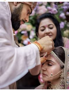 the bride is getting ready for her big day with friends and family onlookers