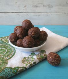 a white bowl filled with chocolate truffles on top of a green and white napkin