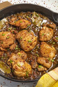 a skillet filled with meat and vegetables on top of a table