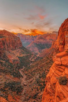 the sun is setting over canyons and mountains in the desert, with trees on both sides