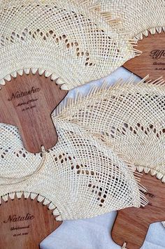 three wooden paddles with lace on them sitting on top of a white table cloth