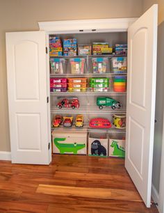 an open closet with toy cars and toys in the bins on the floor next to two doors