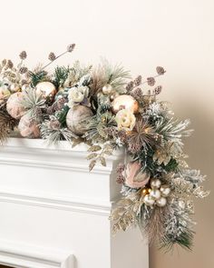 a decorated fireplace mantel with ornaments and greenery