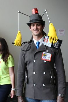 a man in a costume made to look like a doctor who is holding two yellow gloves