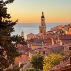 the city is next to the water and has many buildings on it, including one with a bell tower