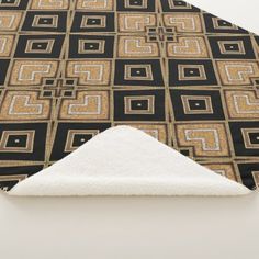 a black and gold geometric pattern with white rug on the floor next to an area rug