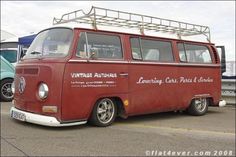 an old red van parked in a parking lot