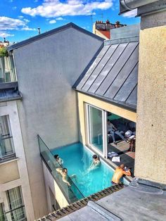 people are swimming in an outdoor pool on the roof of a building