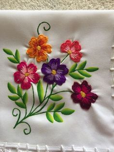 a close up of a piece of cloth with flowers embroidered on the front and back