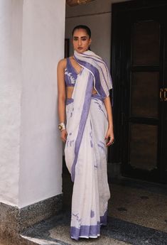 Step into timeless elegance with the Kalina Saree, crafted from airy linen gauze fabric that drapes like a dream. The contrast border adds a striking frame to the soft, flowing material, while delicate floral motifs dance across the saree, lending it a touch of nature's grace. The Kalina Saree is more than just attire; it's a celebration of beauty and grace in every fold. Model Name- Mohini  Vitals Height- 5.8 Bust- 34 Waist- 26.5 Hip- 35 Shoulder- 15.5 Fabric: 100% Linen Characteristics of Linen : Hygroscopic All Natural UV Protection Kind On Skin Naturally Breathable Strong Improves With Age Handmade With Love In India By Yell Retail India. Linen Gauze, Linen Saree, Gauze Fabric, Floral Motifs, Floral Motif, Purple Flowers, A Dream, Clothing Items, Timeless Elegance