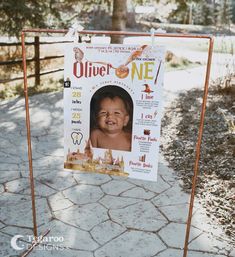 a poster with a baby's face on it is hanging from a metal frame