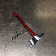 a red handled wrench laying on top of a metal table