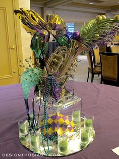 an arrangement of musical instruments is displayed on a purple table cloth at a formal function