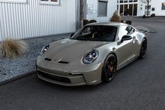 a silver sports car parked in front of a building