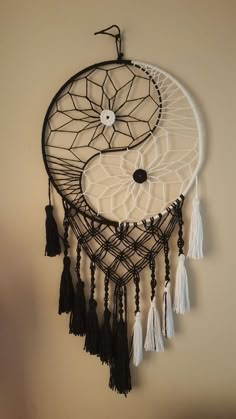 a black and white dream catcher hanging on the wall