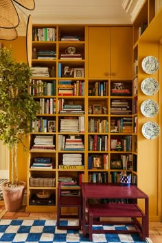 a living room with yellow walls and bookshelves filled with lots of bookcases