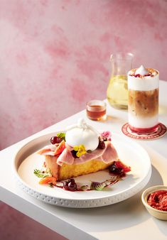 a piece of cake sitting on top of a white plate next to a glass of wine