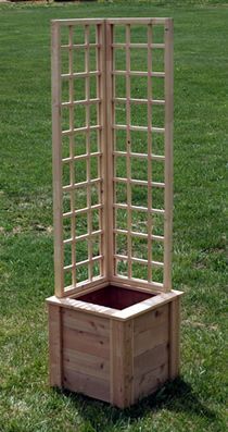 a wooden planter in the middle of a grassy field