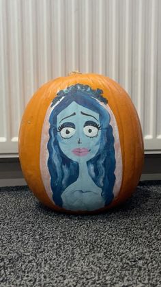 a painted pumpkin with a woman's face on it