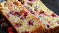 two pieces of cake on a plate with berries and cranberries next to it