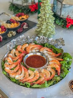 a platter filled with shrimp and lettuce next to other food on a table