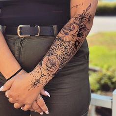 a woman's arm with flowers on it and a black belt around her waist