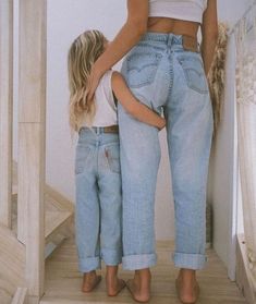 a mother and daughter are standing on the stairs