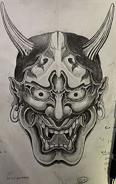 a drawing of a demon mask on paper